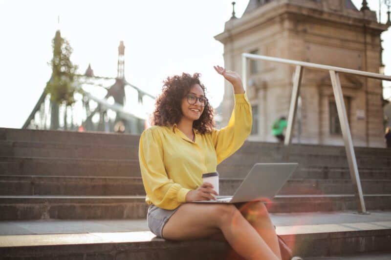 A woman sitting on steps with her laptop.